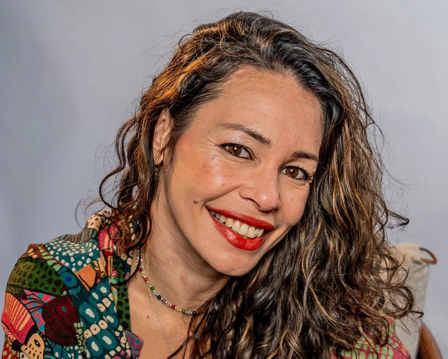 Retrato da cantora Meriele, sorrindo, de blusa estampada