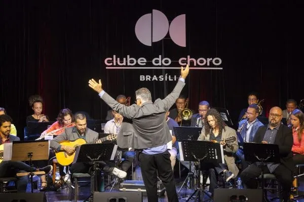 Choro Popular Orquestra no palco do Clube do Choro de Brasília, com o maestro de costas regendo os músicos