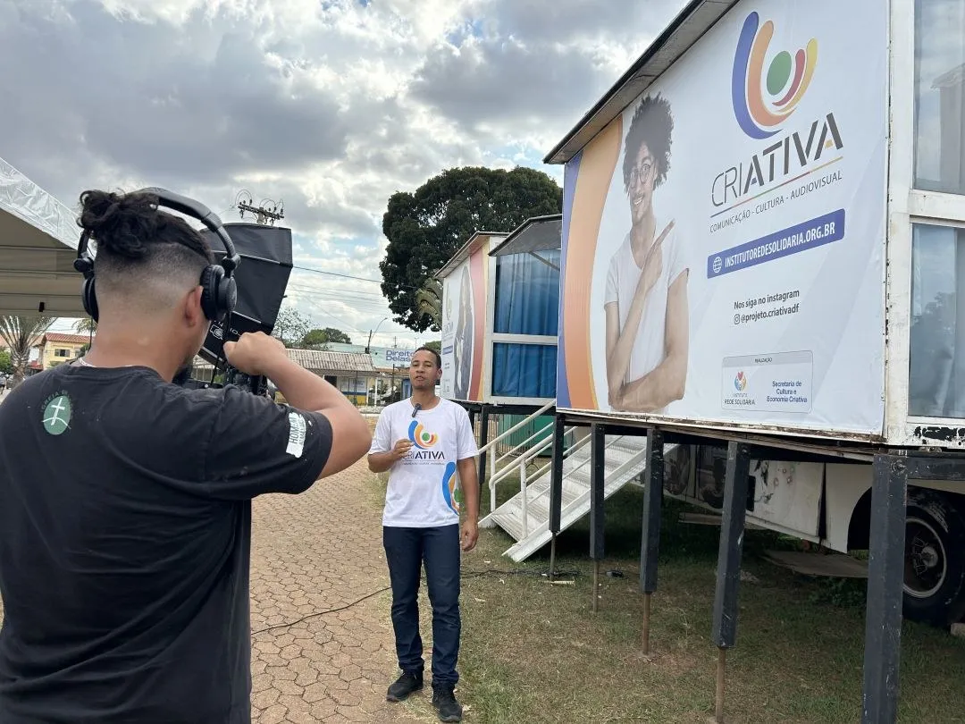 Cinegrafista grava apresentador diante da carreta do projeto CriAtiva